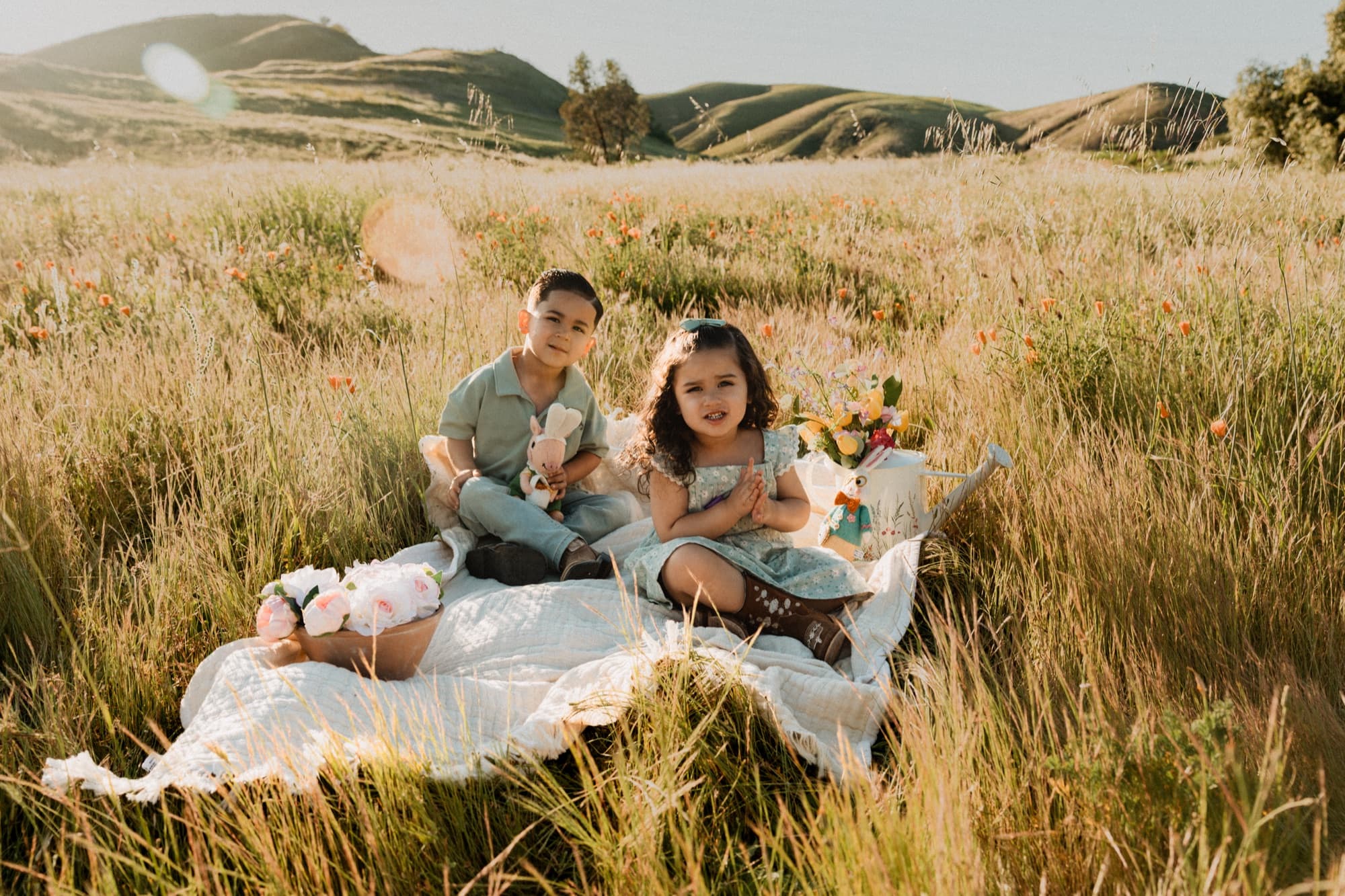 Couple sitting in an open field at golden hour
