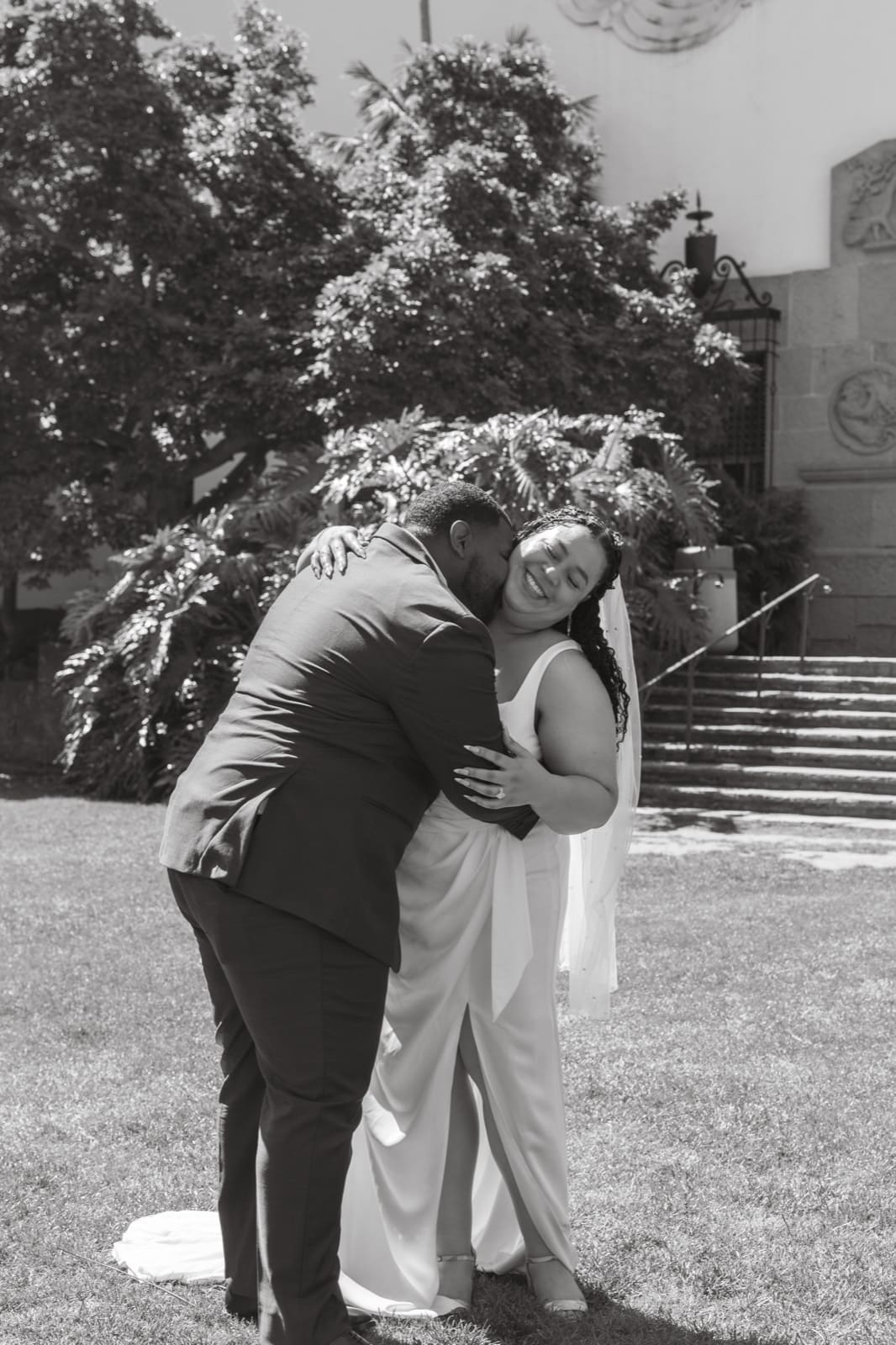 Black and white — groom lifting his bride on the steps