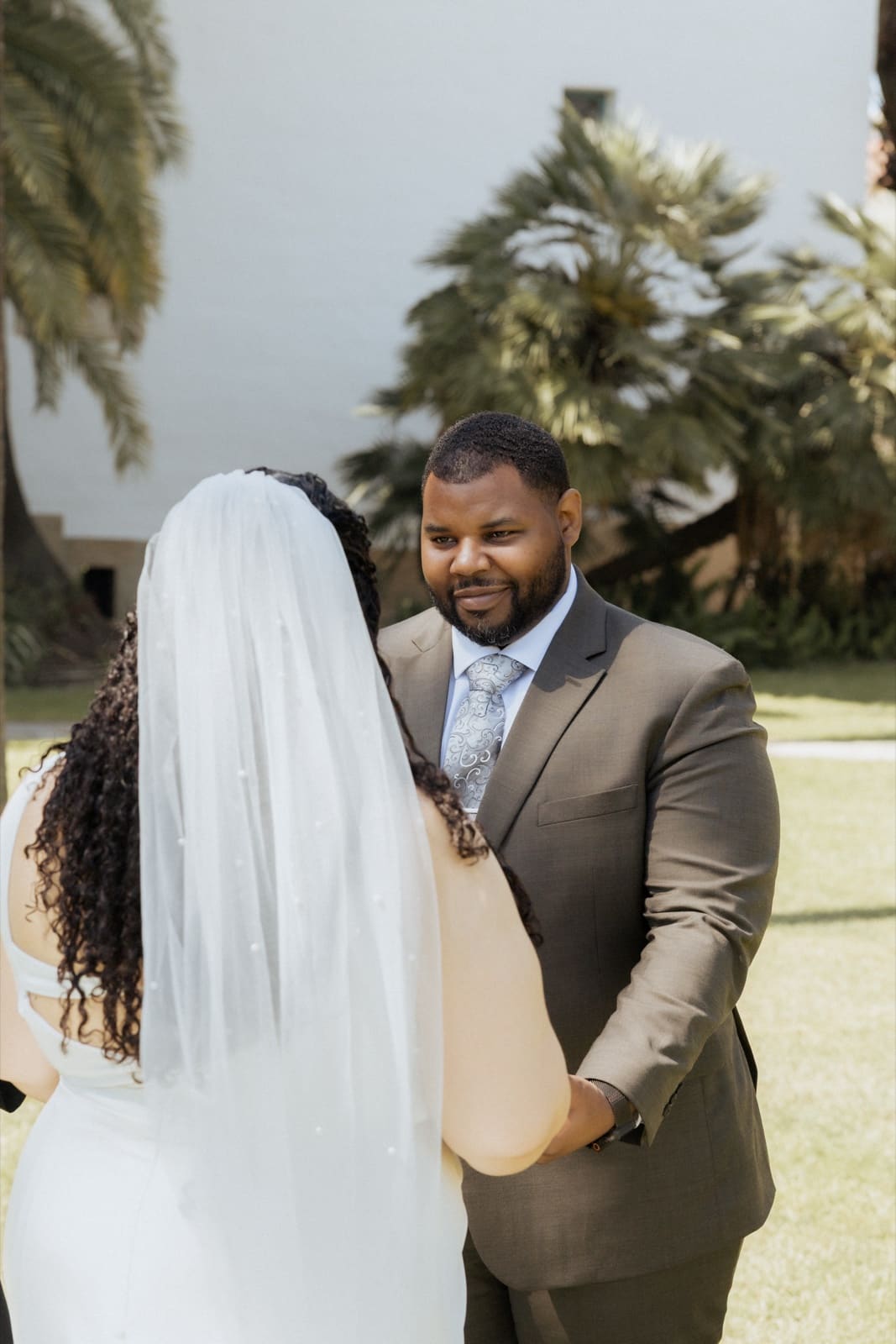 Groom holding his bride, veil across the frame