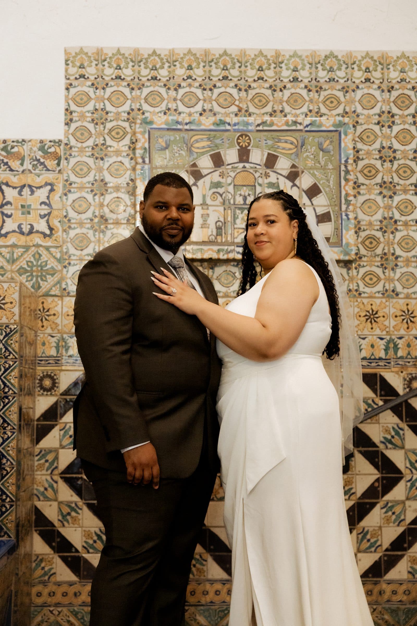Couple portrait against the hand-painted tile stairwell of the Santa Barbara courthouse