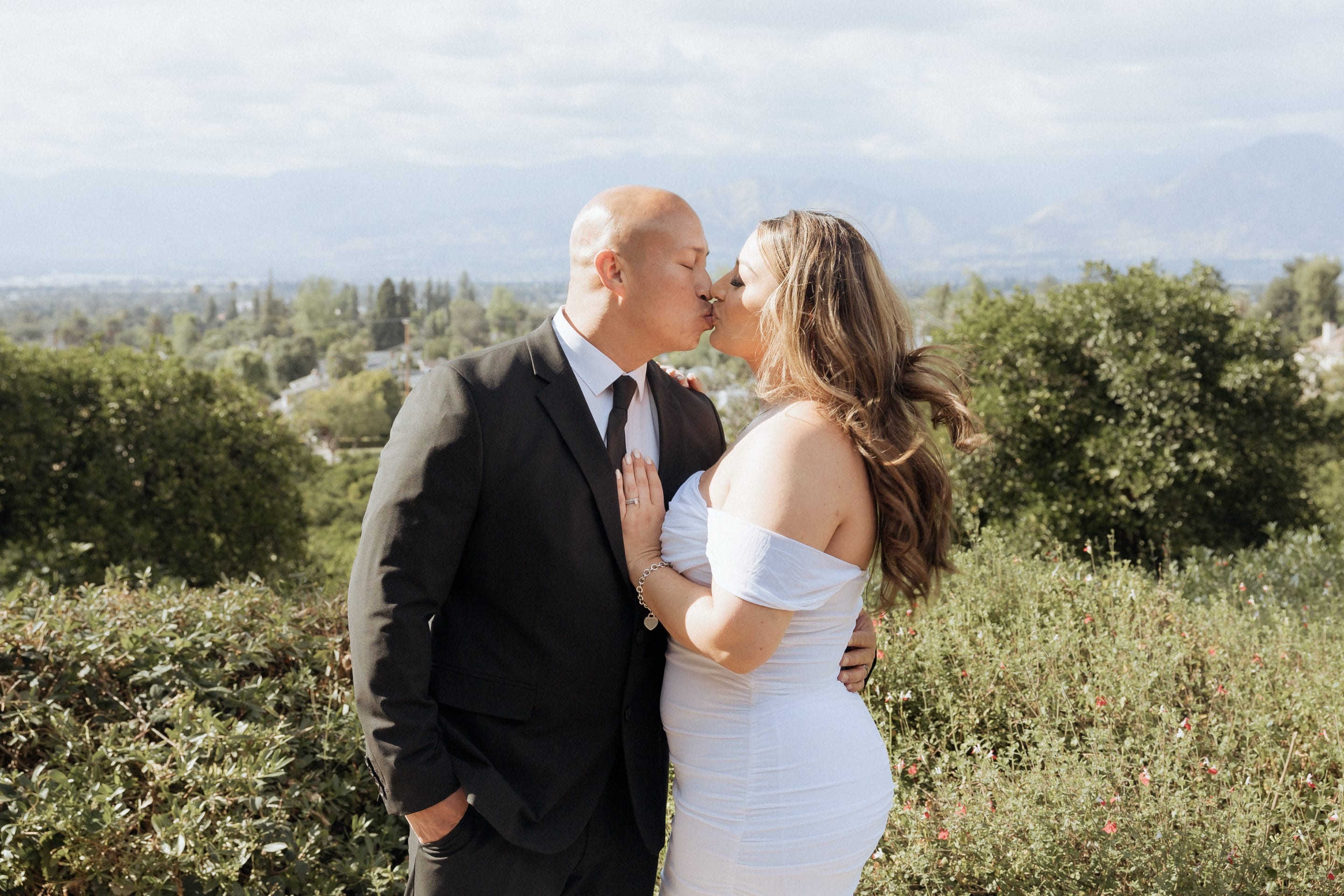 Victoria and Walter kissing on a hilltop above the Inland Empire after their courthouse elopement — Vida Visual