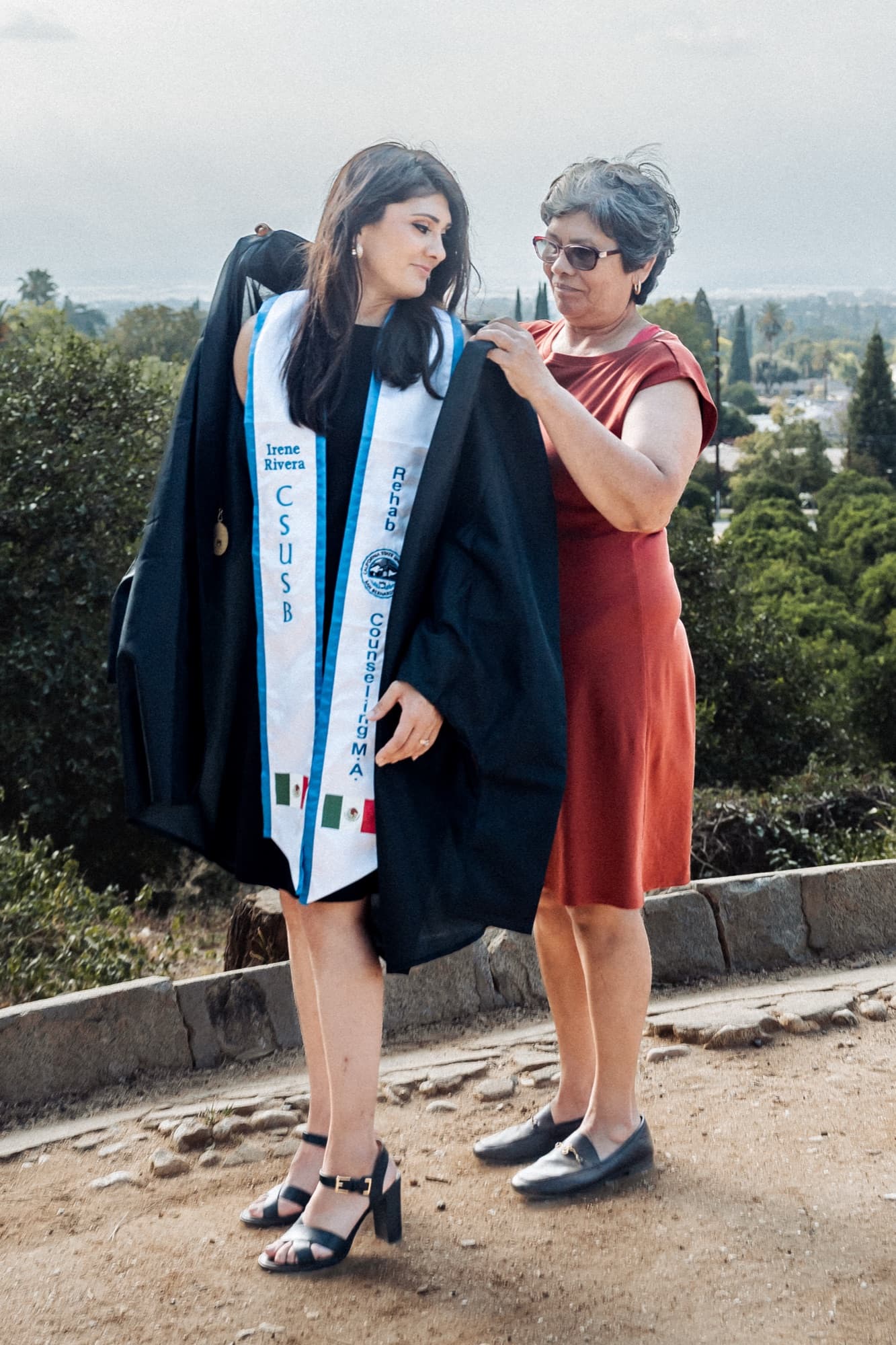 A mother helping her daughter into her graduation gown — Inland Empire, California