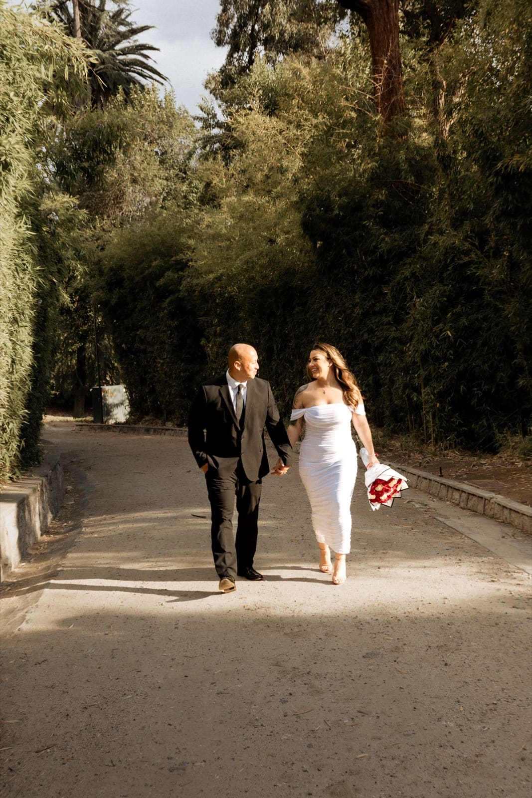 Groom leading his bride down the path