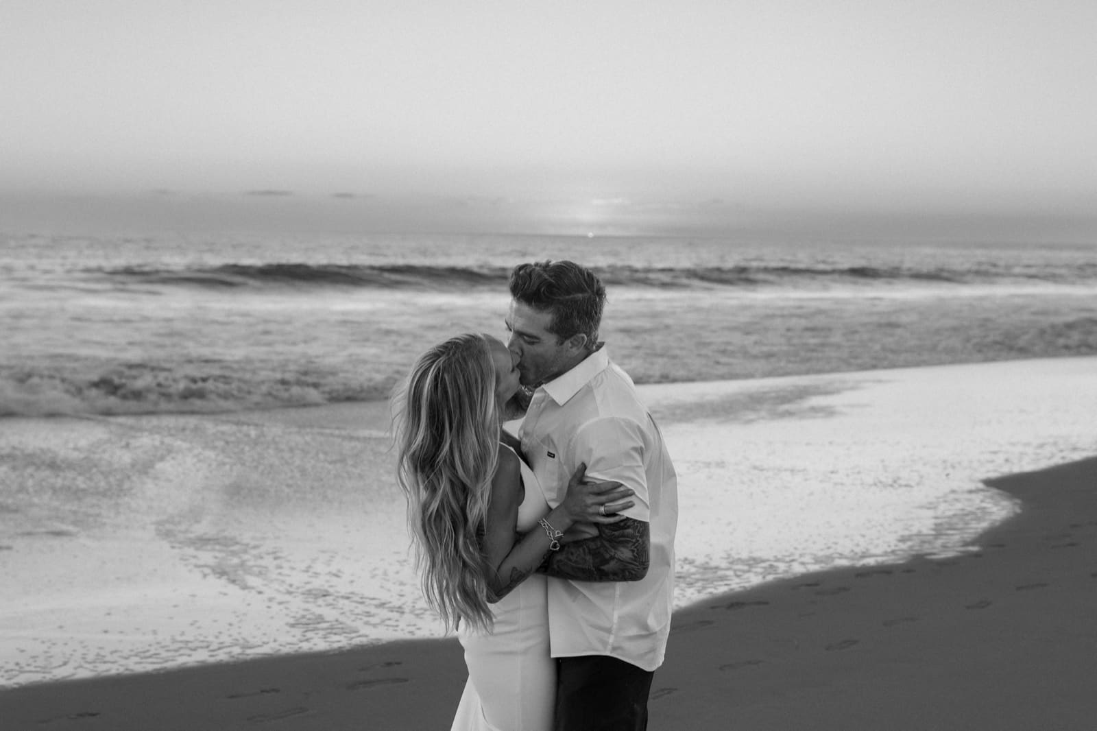 Black and white — couple at sunset on the sand