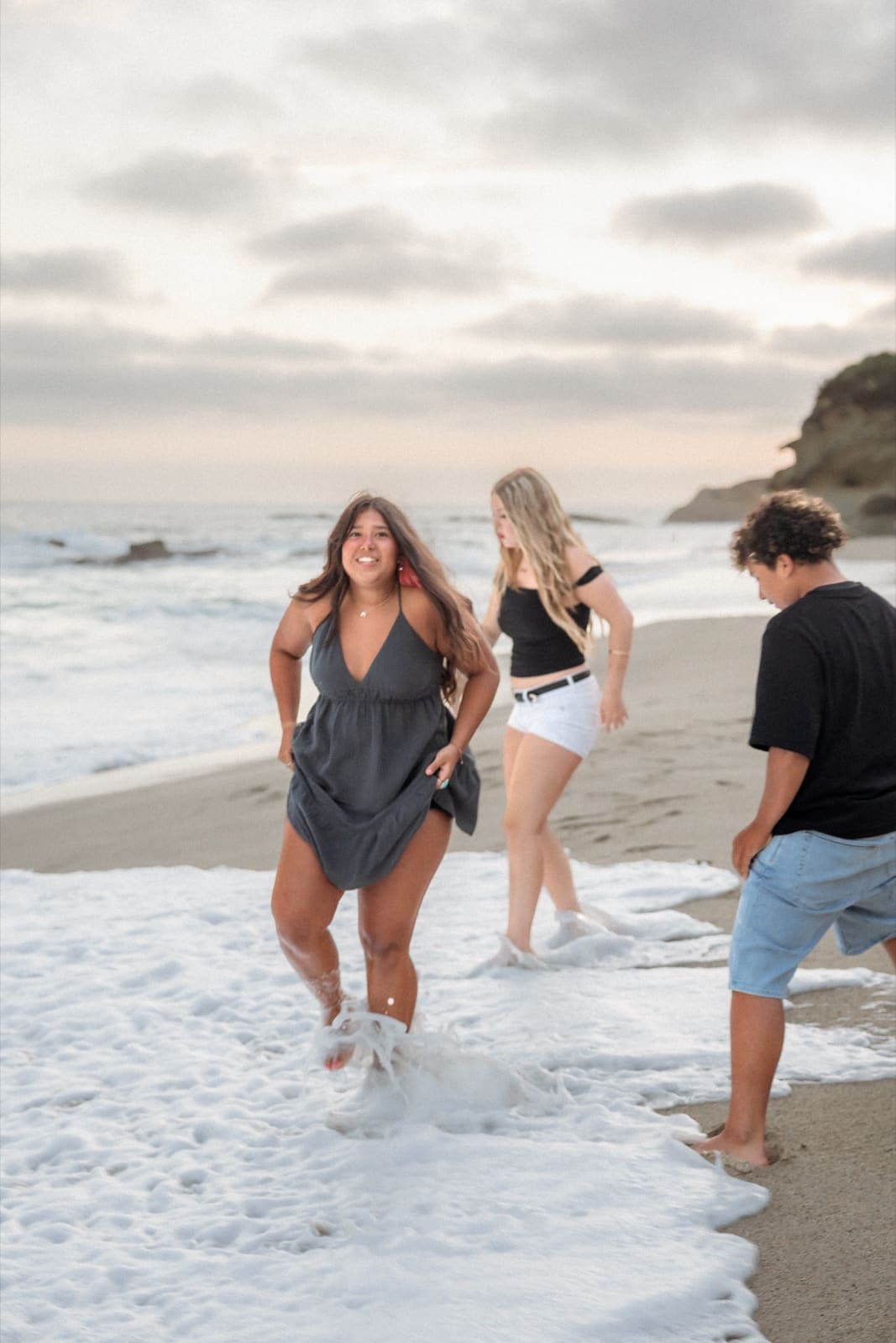 Family running into the surf at Laguna Beach