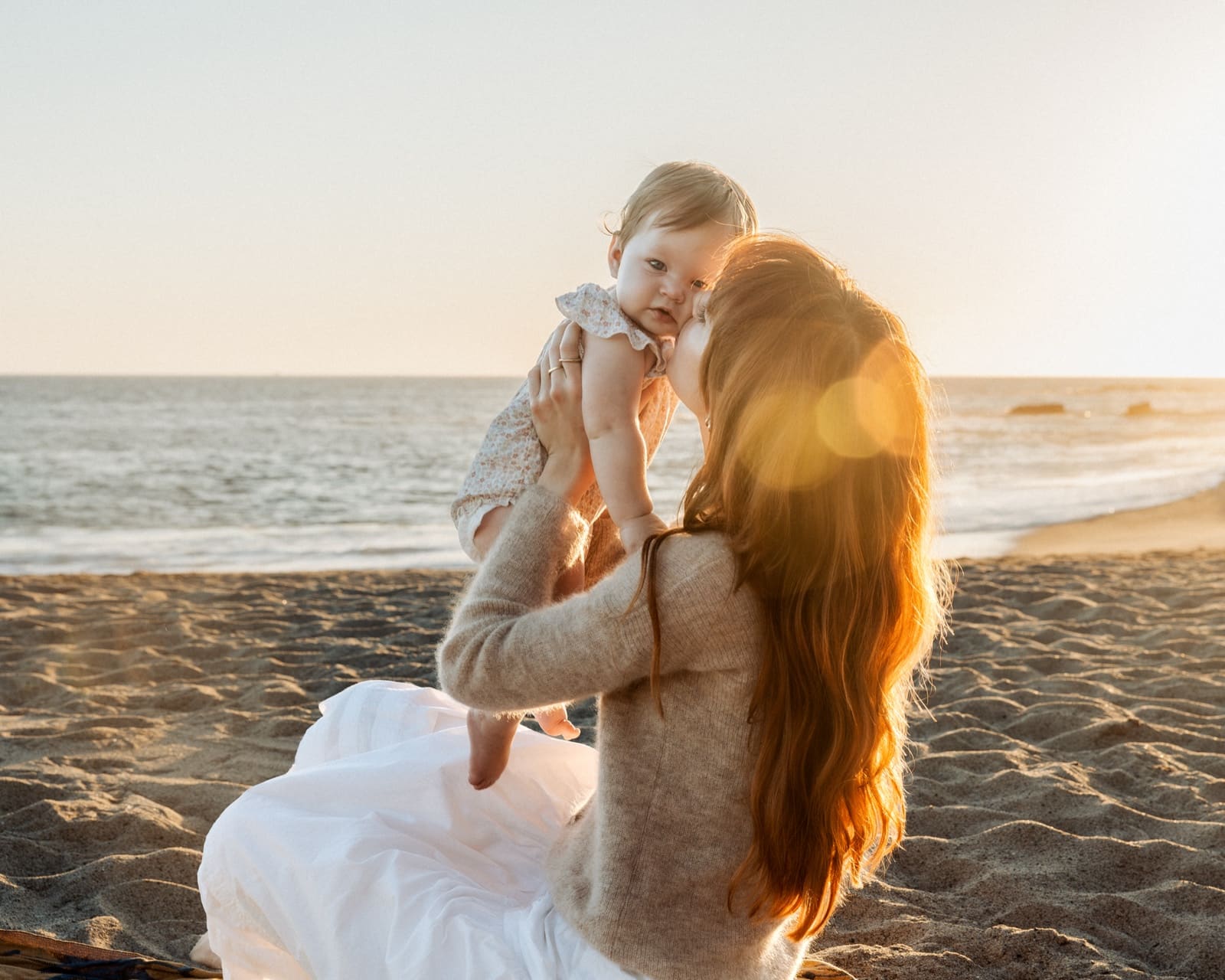 Mother and daughter close, ocean behind