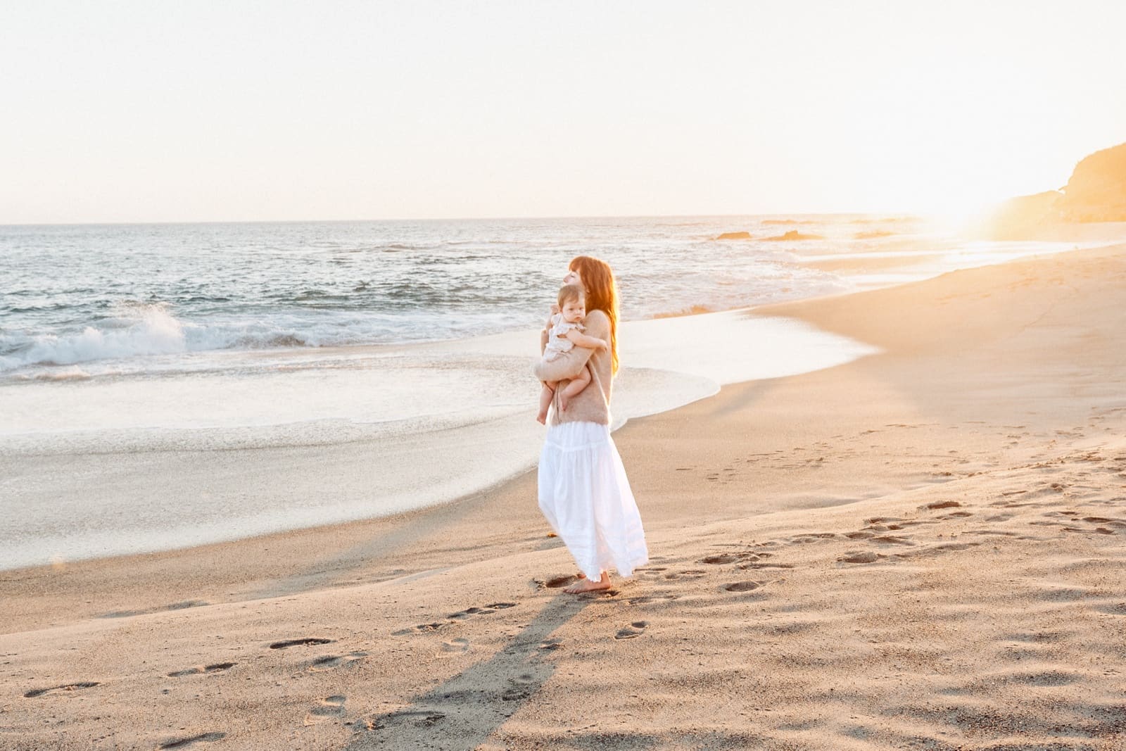 Woman in white walking the tideline at Laguna
