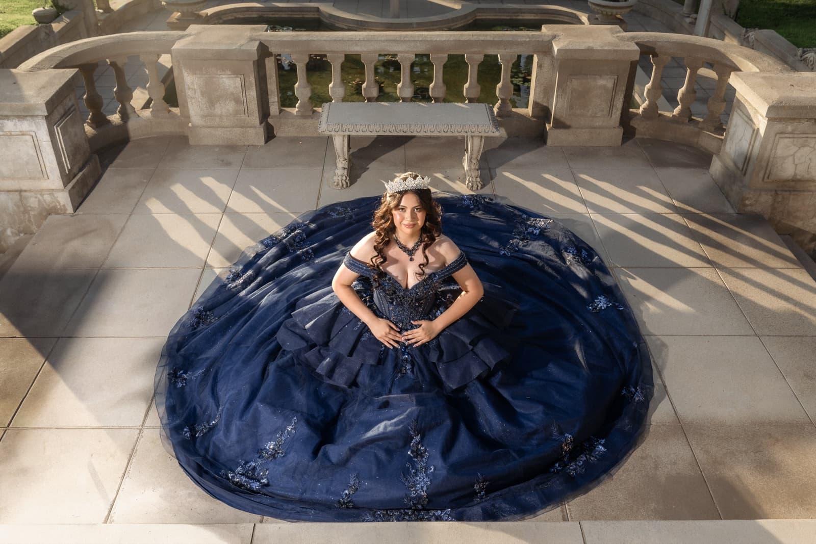 Quinceañera en vestido azul marino en las escaleras de Kimberly Crest House, Redlands