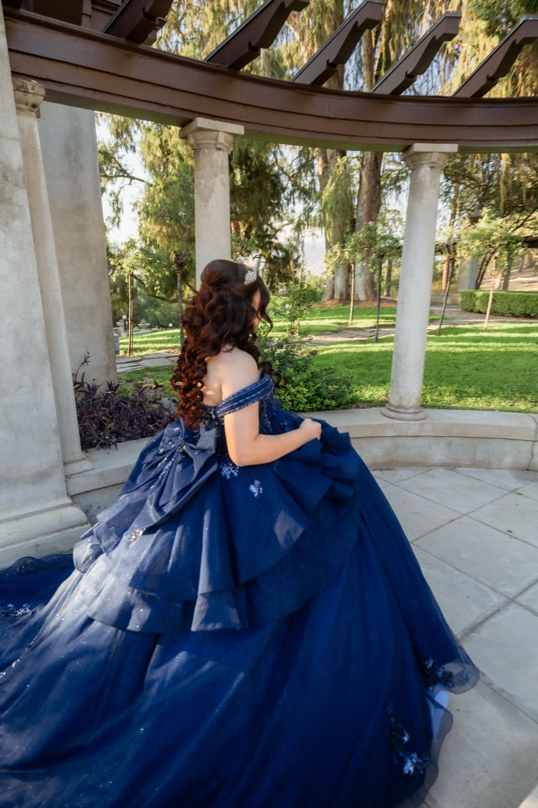 Quinceañera looking back over her shoulder in the Kimberly Crest gardens
