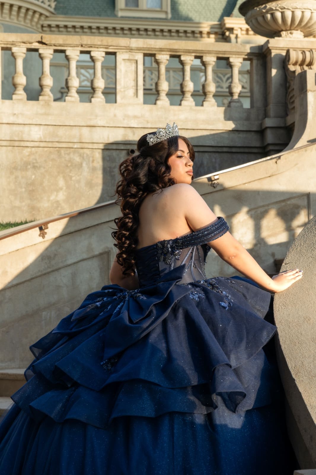Quinceañera holding her skirt out, estate terrace