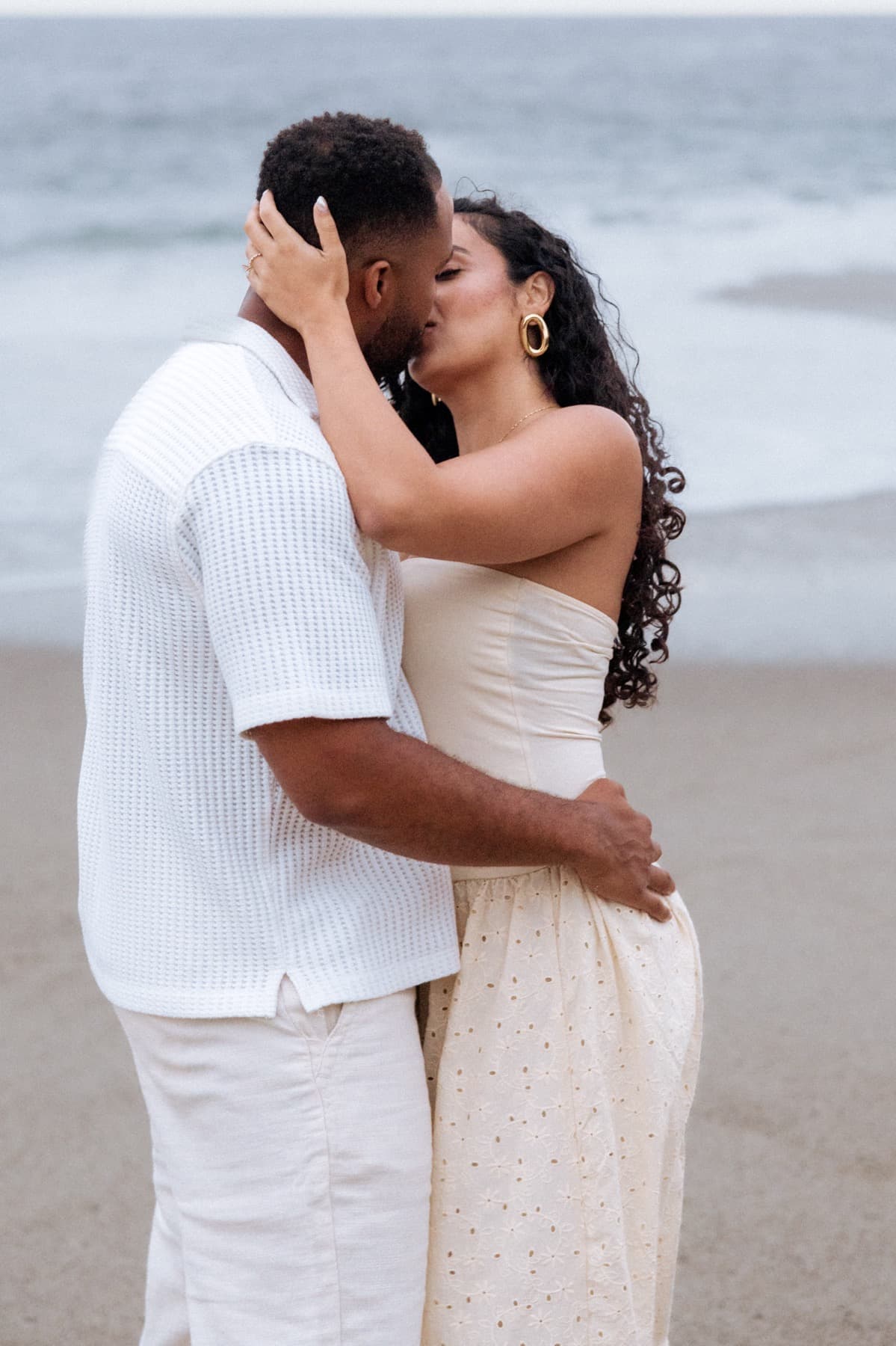 First kiss as an engaged couple on the sand at Laguna Beach