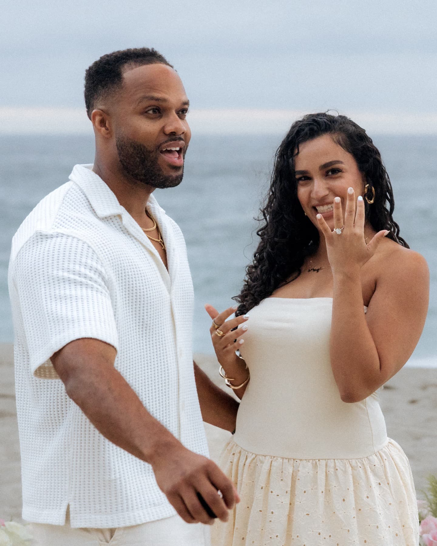 Newly engaged couple showing the ring on the beach at Laguna
